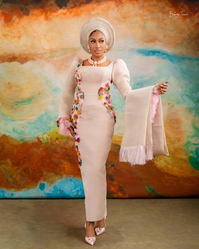 Cream Aso-Oke Asoebi with Multicolour Floral Tassels, Pink Feather Fringe Ipele & Abstract Art Backdrop | OutfitLibrary