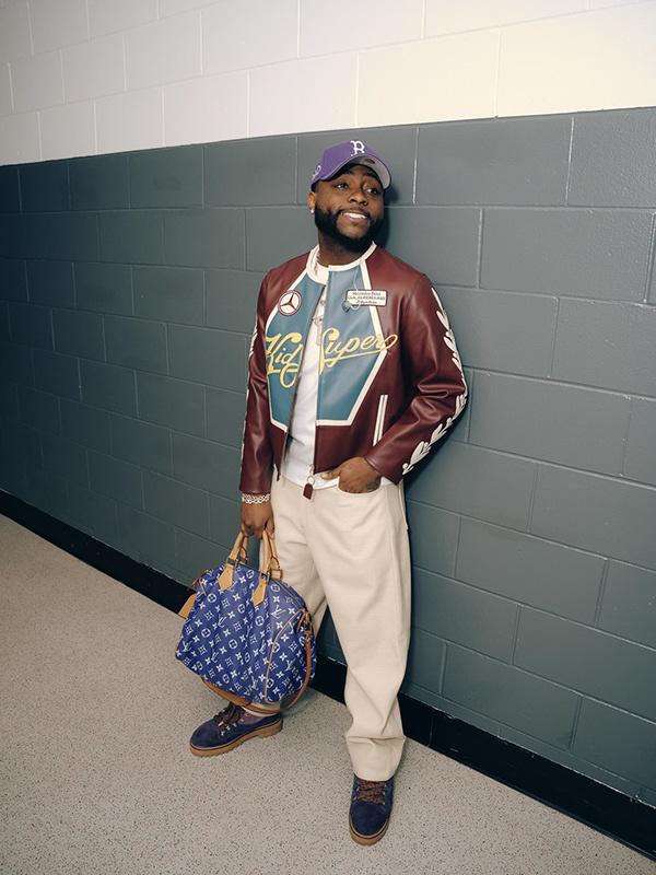 Davido in Burgundy Varsity Jacket, Cream Trousers & LV Duffle Street Style | OutfitLibrary.com